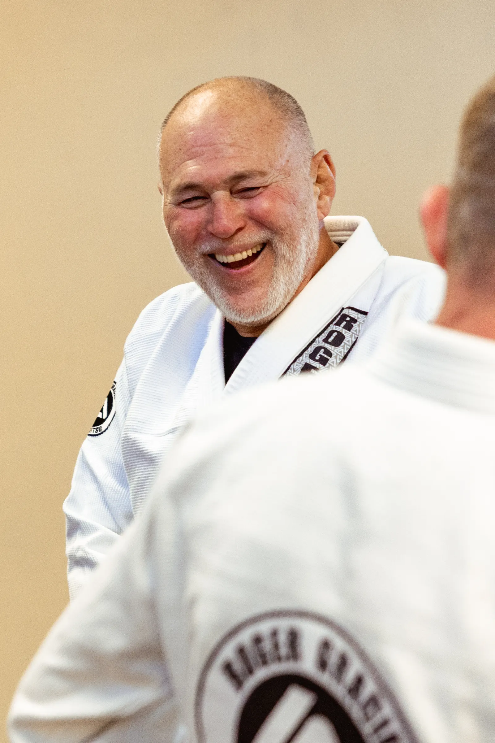 Mauricio Gomes laughing with a student at Roger Gracie Academy